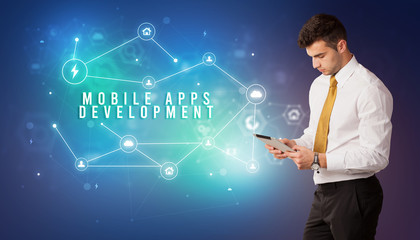 Businessman in front of cloud service icons with MOBILE APPS DEVELOPMENT inscription, modern technology concept