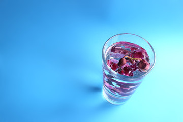 spa Background - Blurred pink orchid in a glass with water. Bubbles on the flowers. Organic cosmetics. Natural water.