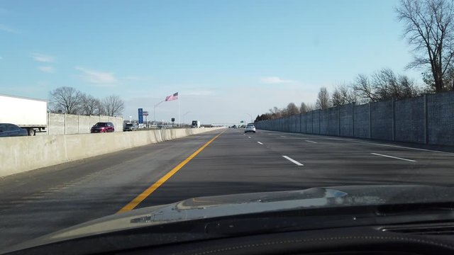 Driving Down American Freeway With Big American Usa Flag On Left Hand Side Past Trailer Park Toledo Ohio During Daytime First Person View