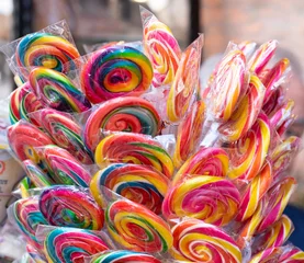 Foto op Plexiglas Colorful bright assorted candy canes and rainbow colored spiral lollipops with scattered marmalade, jellybeans and different colored round candy. © Caner