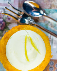 A Lemon Lime Syrup Cupcake on a colourful background with white icing