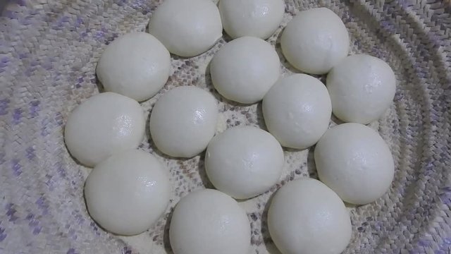 A woman making a balls of paste to prepare traditional Moroccan crepes called msemen .