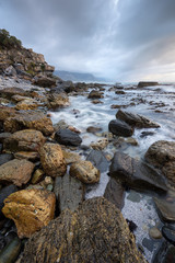Fototapeta na wymiar A beautiful vertical moody seascape taken in hermanus, South Africa, on a stormy, cloudy afternoon.