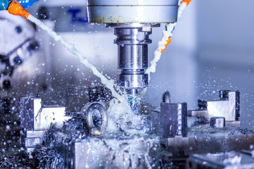 vertical cnc steel milling process with external water coolant streams, splashes and a lot of metal...