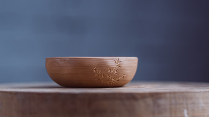 Handmade Clay Bowl Of Yixing Clay On Hand-Painted In The Form Of Bamboo On A Wooden Circle. Clay Pottery Ceramics. High Quality Photo