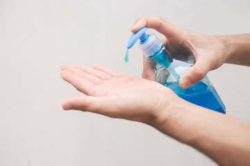 Hand cleaning gel. Pouring sanitising hand gel onto the fingers of a hand to prevent spread of germs, bacteria and virus. Personal hygiene concept.
