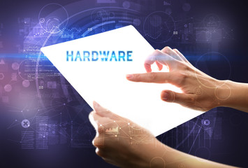 Hand holdig futuristic tablet with HARDWARE inscription, new technology concept