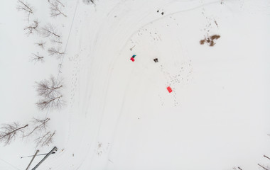 Top down view of two people tobogganing in snow