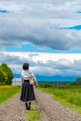 Young asian girl walking on a country road in sunny day