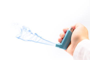 hand with an asthma inhaler on a white background