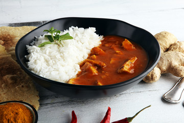 Chicken tikka masala spicy curry meat food in pot with rice and naan bread. indian food on table