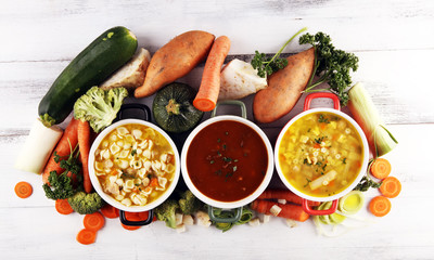 Set of soups from worldwide cuisines, healthy food. Broth with noodles, beef soup and broth with marrow dumplings. All soups with healthy vegetables on table