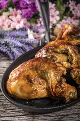 Quarters of fried chicken in a cast iron skillet.