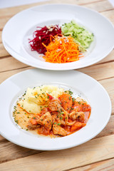 chicken with mashed potatoes and salad on the wooden background
