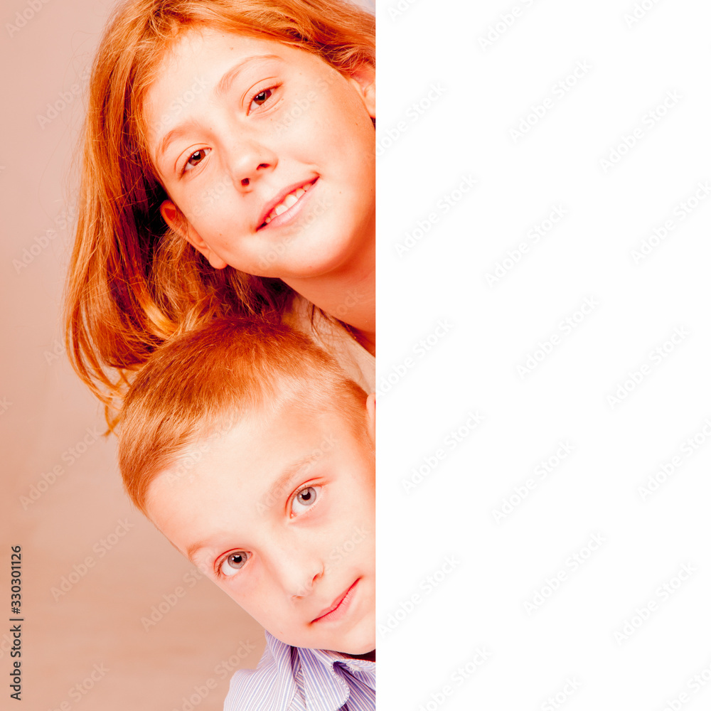 Wall mural Close up portrait of cute child girl and  boy looking behind copy space area. Free space for design.