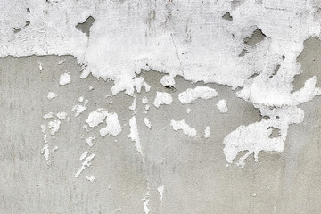 Part of an old concrete wall is covered with old plaster. Shabby building facade with damaged plaster. Grunge concrete wall background texture and place for text