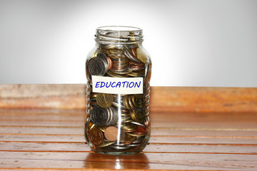 A glass jar full of coins to represents education