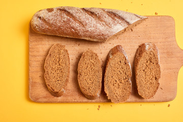 Bread on cut board. Fresh bread on the kitchen table. The healthy eating and traditional bakery concept.