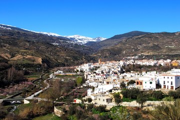 View of the white village of Cadiar with the snow capped mountains of the Sierra Nevada to the rear, Cadiar, Spain.