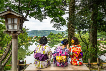 Women wearing traditional Japanese dress sitting on a bench at Kenrokuen Garden, Kanazawa, Japan