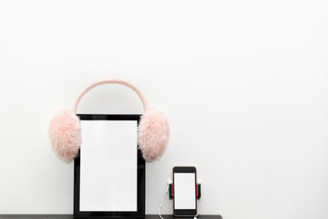 Digital tablet and smartphone with headphones on a white background