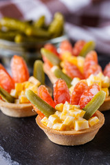 delicious snack tartlets on dark stone background
