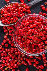 pink peppercorns on a dark stone background