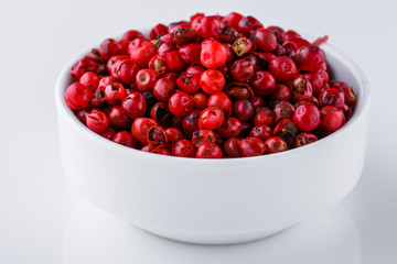 fragrant pink peppercorns on white acrylic background
