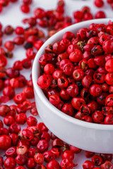 fragrant pink peppercorns on white acrylic background