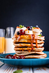 Delicious and lush pancakes with fresh fruits and berries, poured with salted caramel.