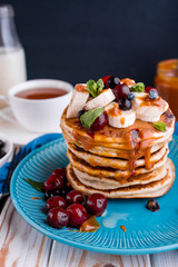 Delicious and lush pancakes with fresh fruits and berries, poured with salted caramel.