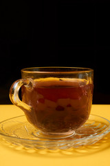 Glass teapot and a cup of tea with lemon