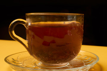 Glass teapot and a cup of tea with lemon
