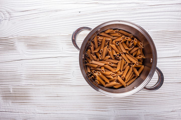 traditional italian pasta in a metal pan on a wooden background