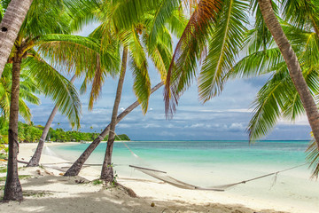 Palm trees on a white sandy beach at Plantation Island, Fiji, South Pacific - obrazy, fototapety, plakaty