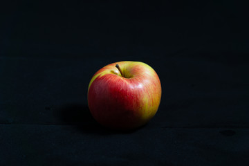 Fototapeta na wymiar Ripe apple on black velvet