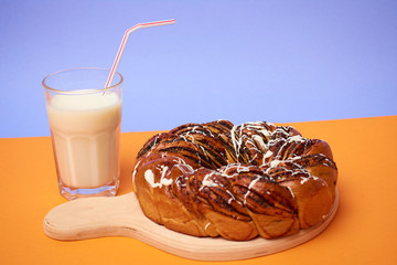 Braided roll with poppy seeds and cinnamon on yellow background. Top view