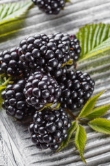 juicy blackberries on gray wooden rustic background