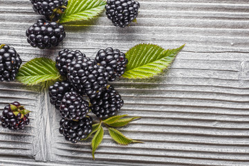 juicy blackberries on gray wooden rustic background