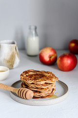 Homemade buckwheat apple pancakes with honey on light background. Pescajounes.  Hard light, deep shadow. Selective focus