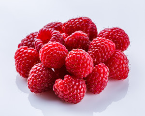 Juicy fresh natural raspberries on white acrylic background