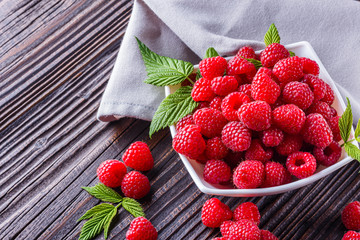 juicy fresh natural raspberries on a dark wooden rustic background