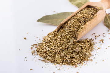 ground dried bay leaf on white acrylic background