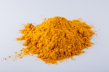 natural turmeric powder on white acrylic background