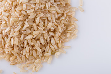 raw brown rice on white acrylic background