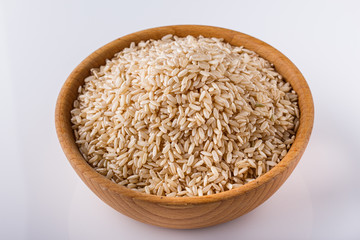 raw brown rice on white acrylic background