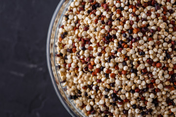 mix of quinoa grains on a dark stone background