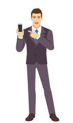 Smiling Businessman pointing at a mobile phone. Full length portrait of Businessman in a flat style.