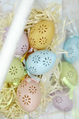 Naklejka na ściany i meble Pastel lace Easter eggs in nest over wooden background