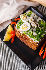 a huge herring sandwich with mayonnaise and quail eggs